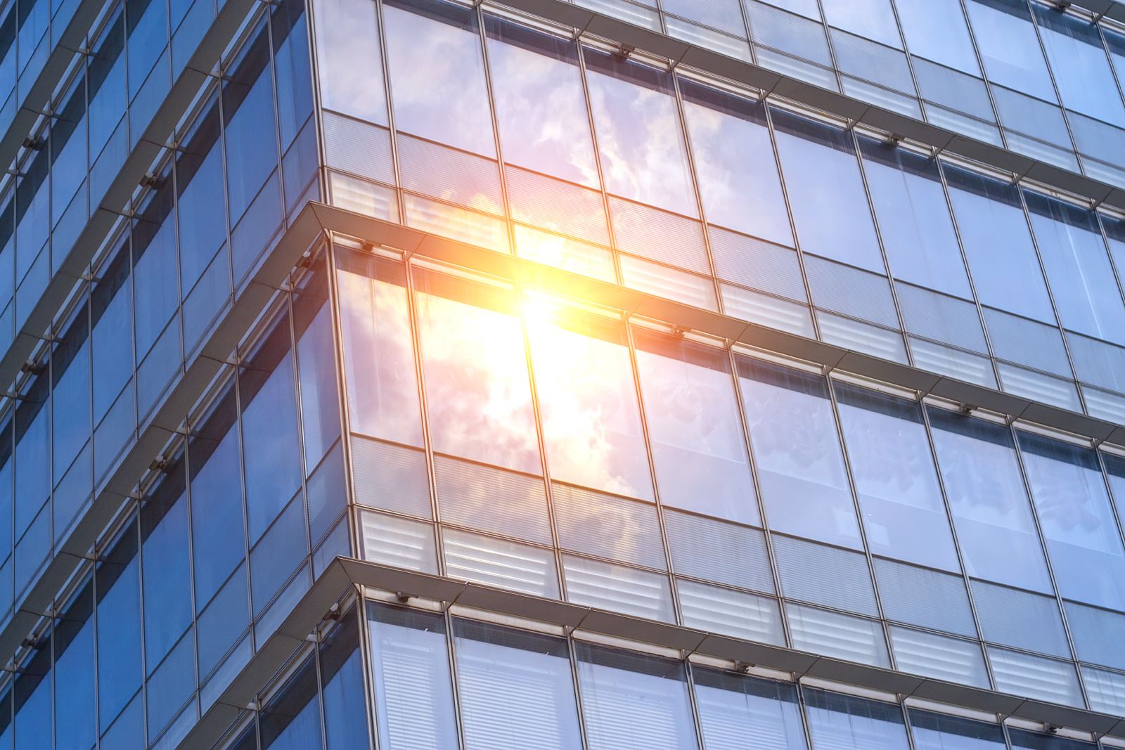Façade vitrée d'immeuble avec fort ensoleillement et reflets du soleil